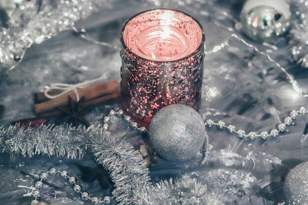 Photo shiny candlestick with a burning candle with festive decorations