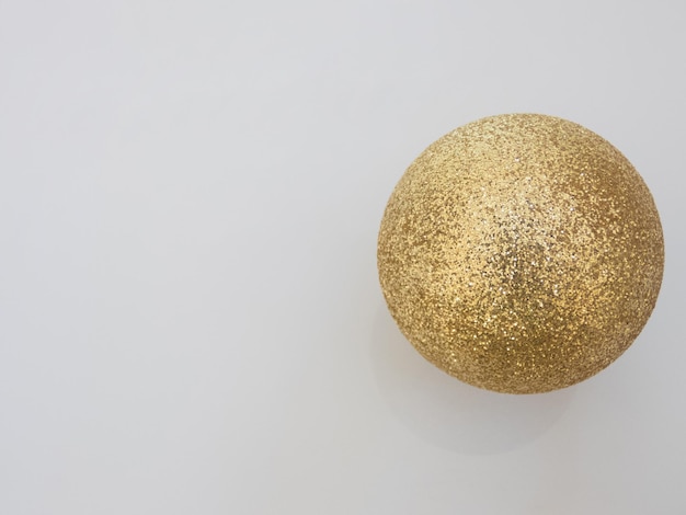 Shiny Christmas ball gold color on a white background top view