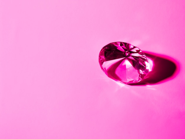 Shiny crystal diamond on pink background