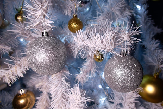 Shiny gold and silver christmas spheres on christmas tree with space for text