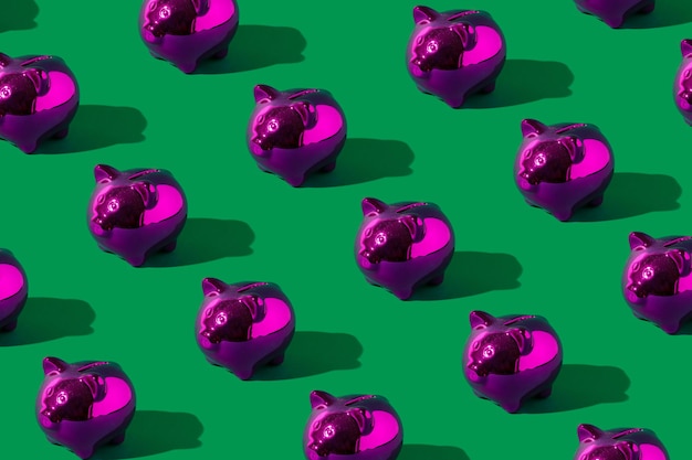 Shiny pink piggy bank on green background. Minimal financial and money saving pattern concept.