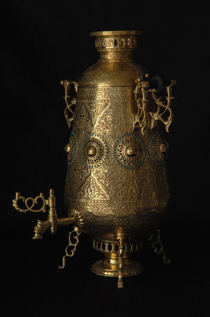 Photo shiny samovar engraved on a black background