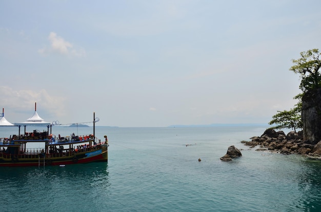 Ship cruise or boat tour stop for send receive thai people and foreign travelers travel visit rest relax and play swimming water in sea ocean in Gulf of Thailand at Koh Chang island in Trat Thailand