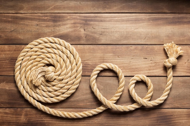 Ship rope at wooden background texture, top veiw