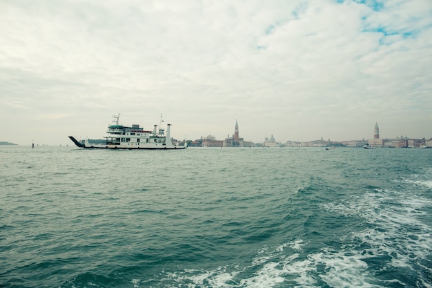 Ship sailing on background of cityscape