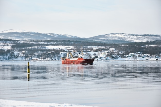 Ship sailing on the sea against the background of snow-capped mountains