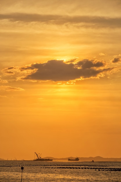 Ship and sunset behind clouds over in the sea