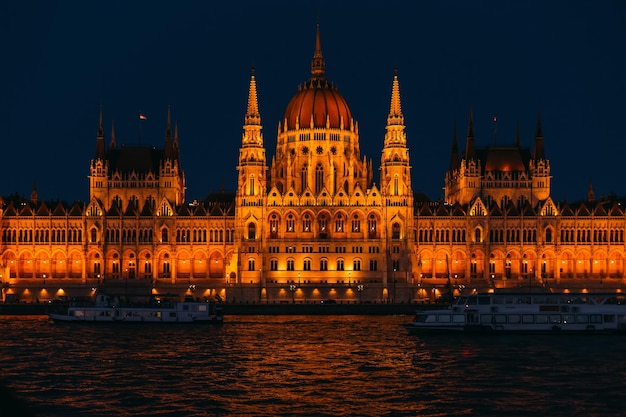 Ships on the river in front of the parliament at night Budapest