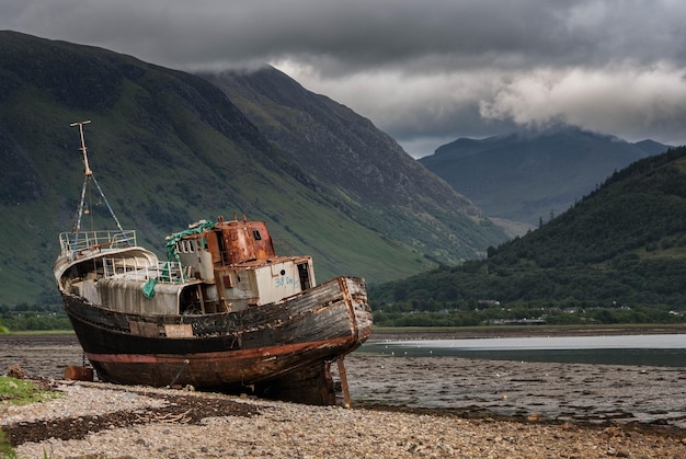 Shipwreck stranded on shore west coast Scotland Misty mountains background