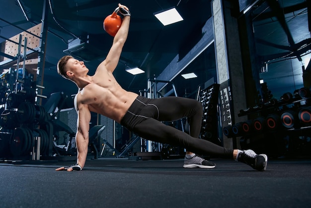 Shirtless bodybuilder doing side plank exercise