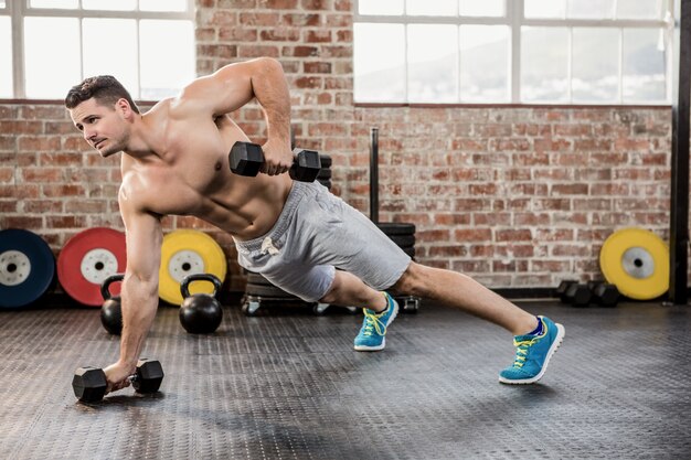 Shirtless man exercising with dumbbell