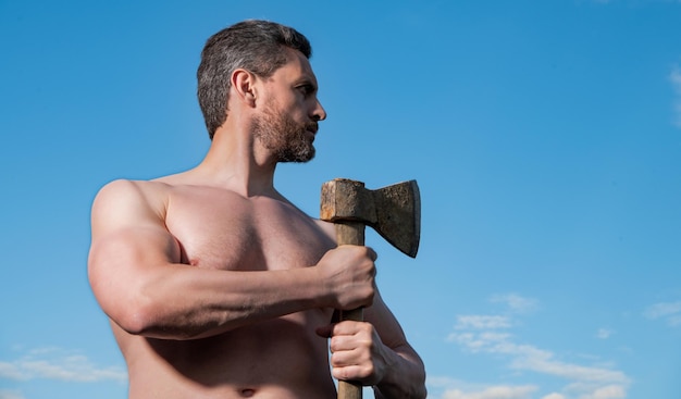 Shirtless man with axe caucasian man hold ax brutal man on sky background with copy space