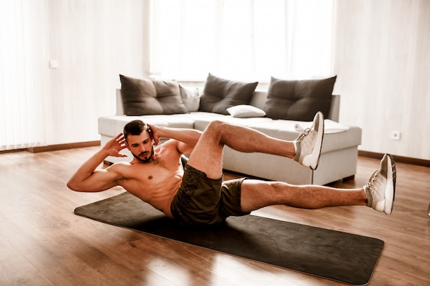 Shirtless man working out at home