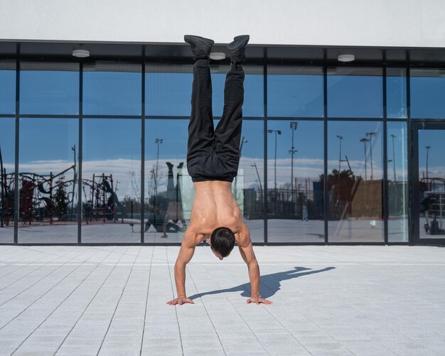 Photo shirtless young man exercising on footpath