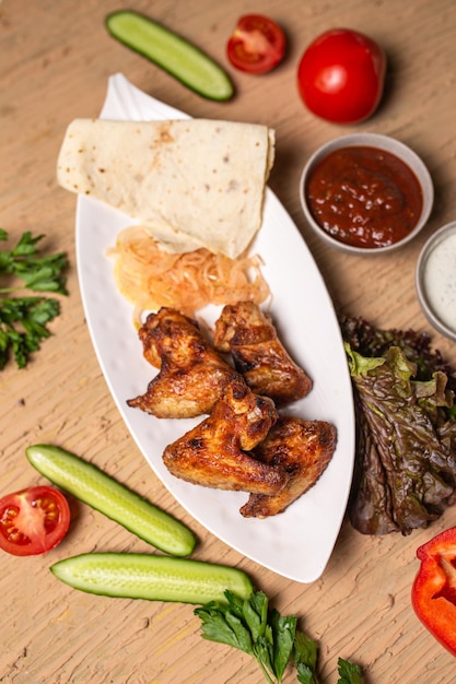 shish kebab of chicken wings on a white plate