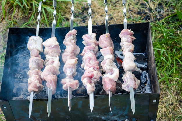 Shish kebab on skewers. Marinated shashlik preparing on a barbecue grill over charcoal. Shashlik or Shish kebab popular in Eastern Europe. Shashlik (skewer meat) was originally made of lamb.