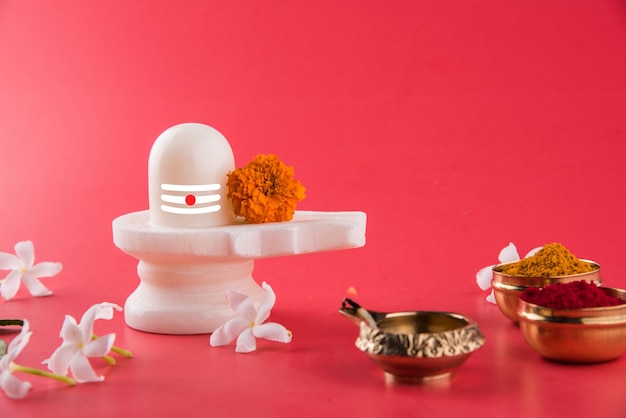 Shiva Linga decorated with flowers & bel patra or leaf and haldi kumkum for Pooja or worshipping of Lord shiva or Shankar bhagwan