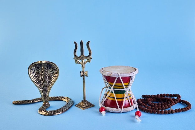 Shivaratri background with shivas trident pellet drum damroo musical instrument ans snake maha shivr