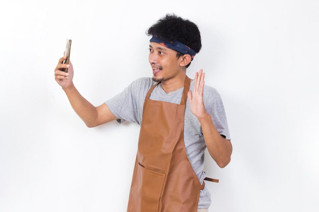 shock asian man barista bartender or waitress using mobile smartphone isolated on white background