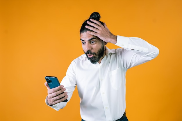 Shocked ethnic businessman reading news on cellphone