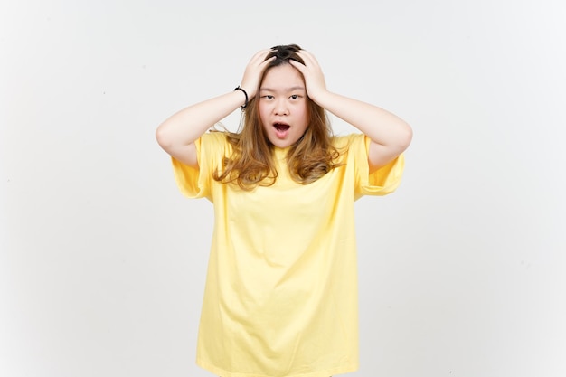 Shocked Face Expression of Beautiful Asian Woman wearing yellow TShirt Isolated On White Background