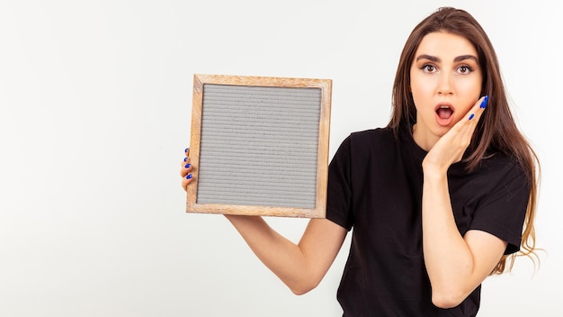 A shocked lady holding board on white background