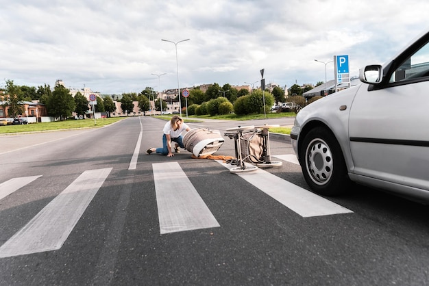 Shocked mother on the crosswalk after car accident when vehicle hits her baby pram