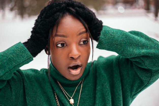 Shocked surprised african american woman standing street outside with white snow background