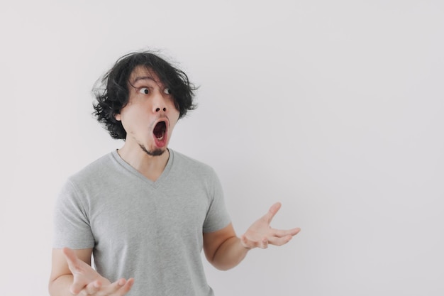 Shocked and surprised face of man in grey tshirt and long hair