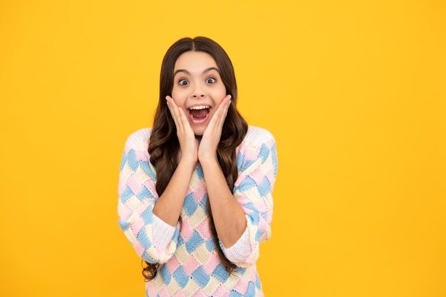 Shocked teenager child with amazed look on yellow background amazement Excited face Amazed expression cheerful and glad