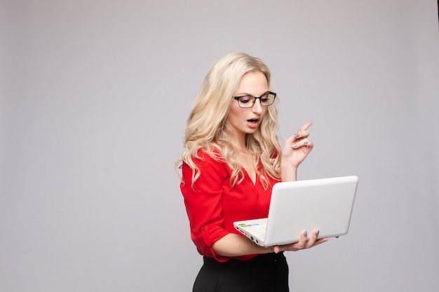 Shocked woman with open mouth keeping computer