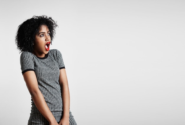 Shocked woman with an open mouth looking aside on a background