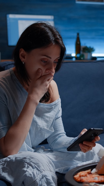 Shocked, worried woman by warning notification for unpaid bank bills received on smartphone