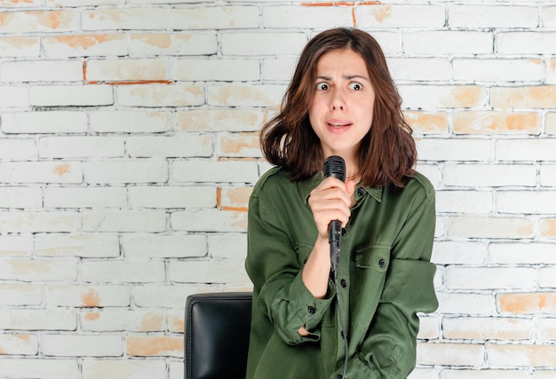 Shocked young lady holding her mic and trying to sing