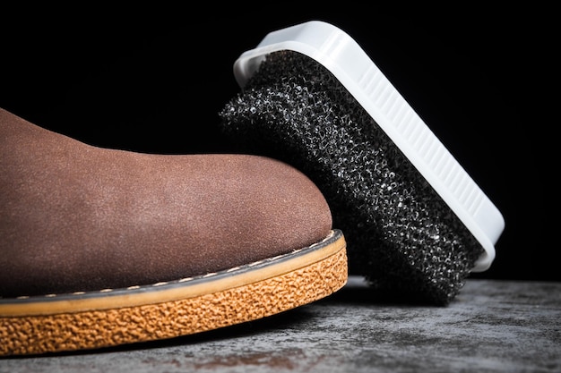 Shoe foam sponge next to a man's brown shoe