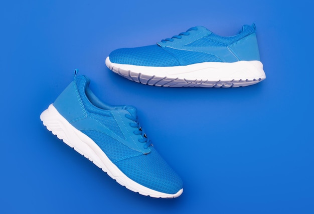 Shoes on blue background. shoe store. shopping concept. footwear for training. athletic footgear for running. pair of comfortable sport shoes. sporty blue sneakers.