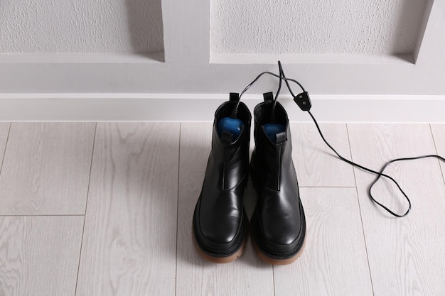 Shoes with electric dryer on floor indoors space for text