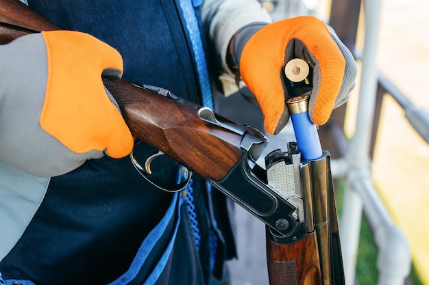 Shooter opens the shotgun bolt and inserts cartridges with shot