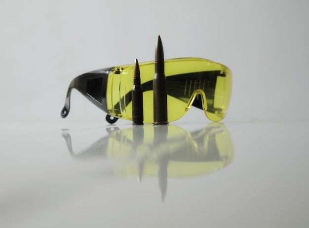 Shooters equipment Special yellow shooting glasses and rifle bullets isolated