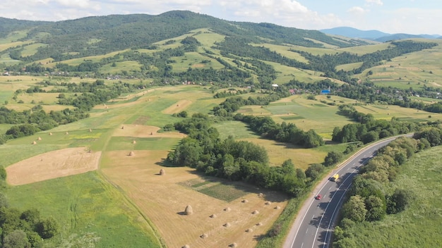 Shooting from the height of the Carpathians in Ukraine Cars drive along a winding road