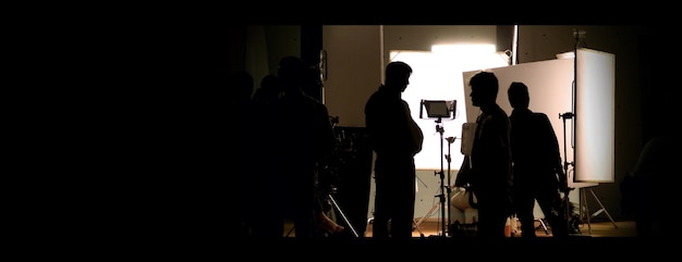 Shooting studio behind the scenes in silhouette images which film crew team working for filming movi