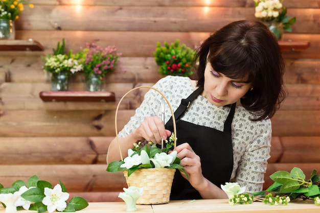 Shop employee collects a bouquet of flowers and soap in a basket