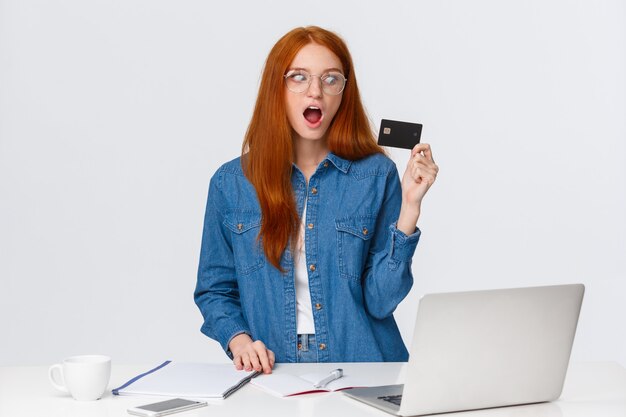 Shopaholic excited buy new things online. Thrilled and shook good-looking redhead