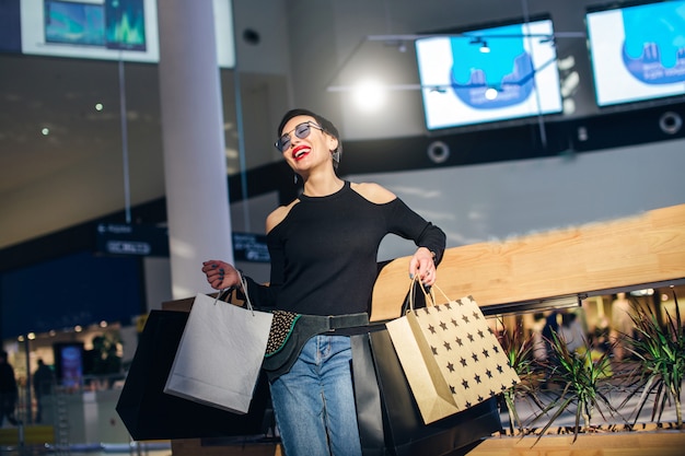 Shopper walking in trade center or mall with shopping bags