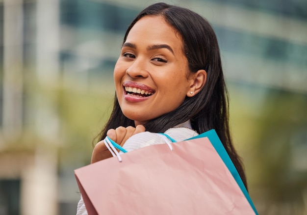 Shopping bag retail and woman in the city for a sale in New York for a discount or store at a mall Face portrait of a happy young and rich girl with bags after shopping during luxury sales in town