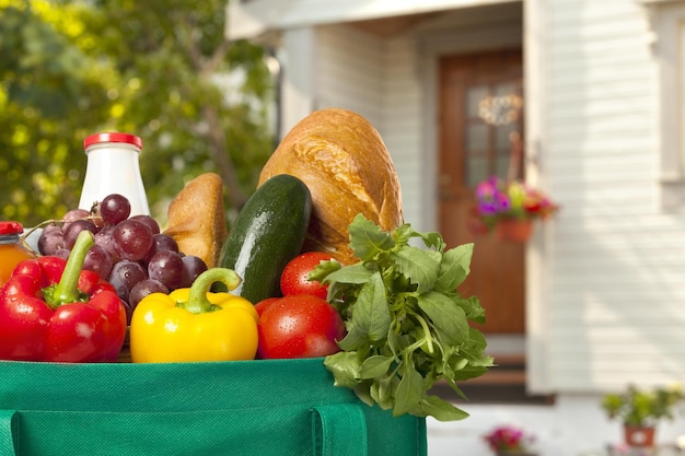 Shopping bag with goods and food at the front door