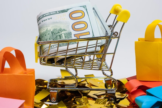 Shopping bags and a cart with money on a white background