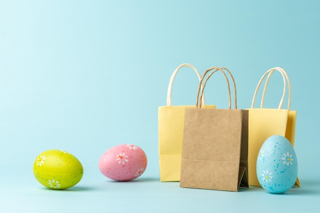 Shopping bags with Easter eggs on blue background