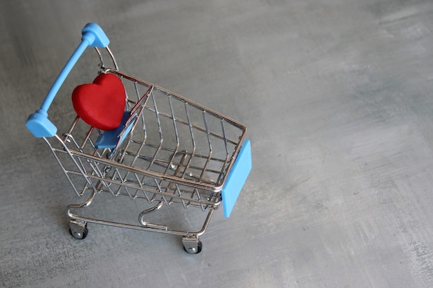 Shopping and buying concept Red heart in shopping trolley