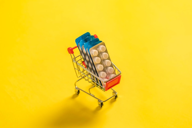 A shopping cart carrying pills and tablets inside concept of medicine and health care online shopping